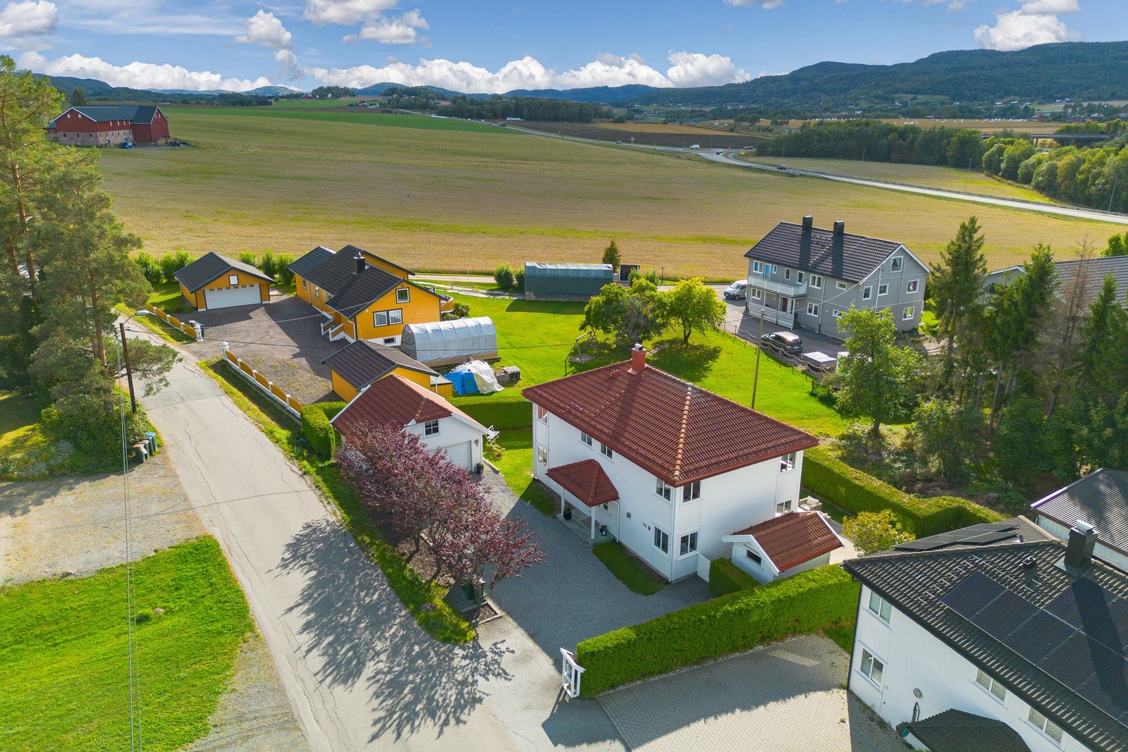 Fra luften ser man hvordan boligen, garasjen, terrassene og hagearealene er samlet på en oversiktlig måte. Galleribilde