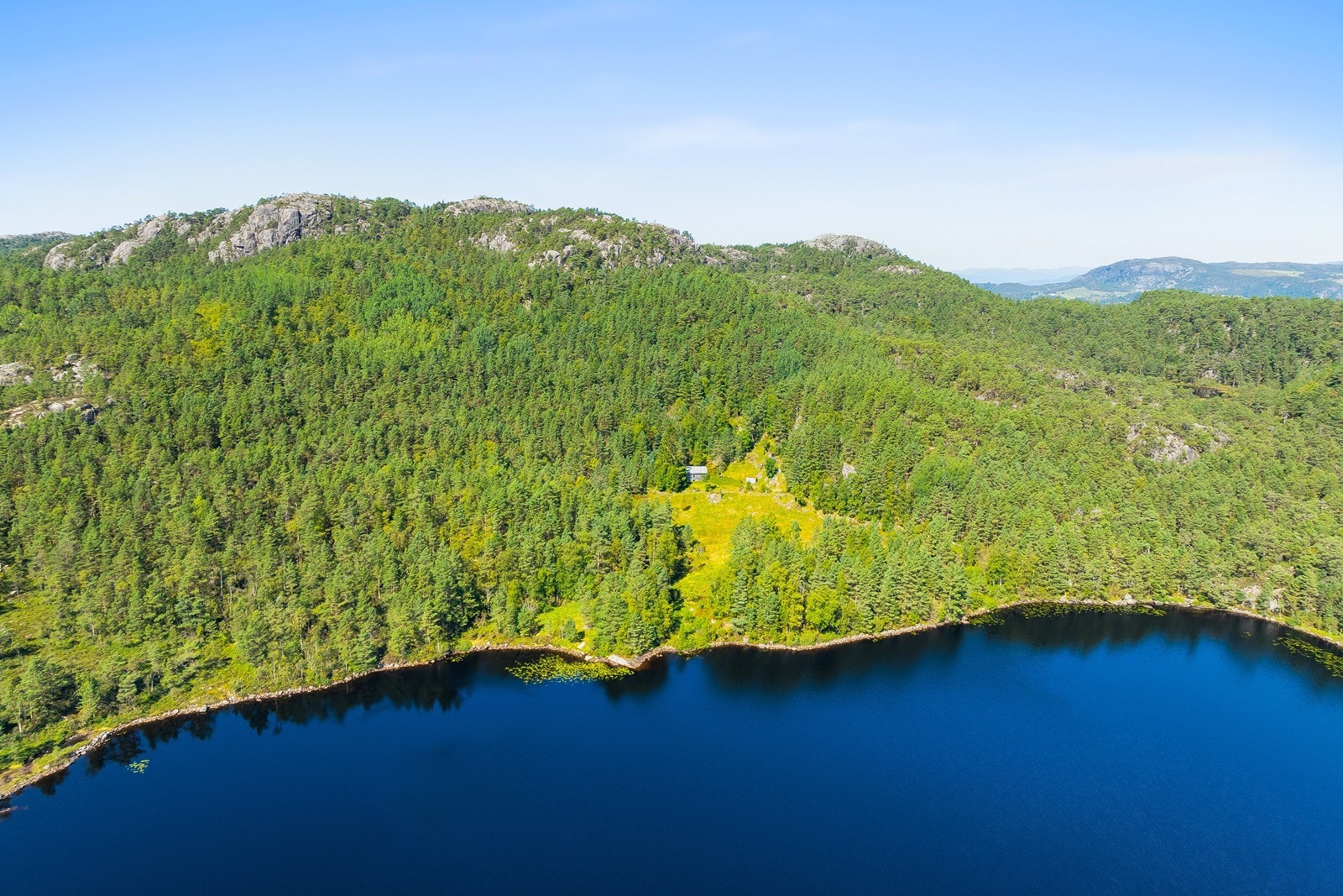 Oversiktsbilde som viser hele eiendommen og den idylliske beliggenheten ved vannet. Galleribilde