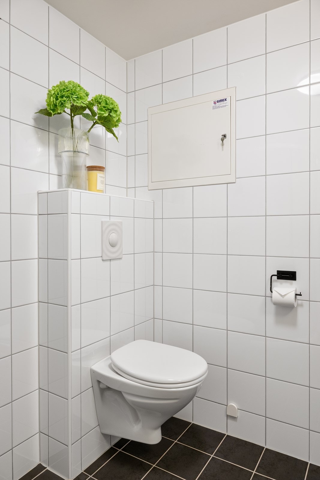 Vegghengt toalett og flislagte overflater bidrar til et rent og tidløst uttrykk. Galleribilde