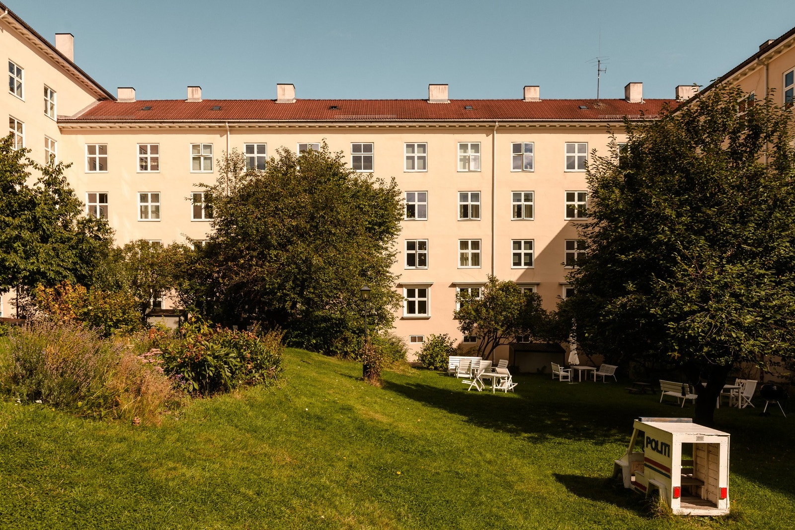 Stor og skjermet felles bakgård med sittegrupper og grillmuligheter for beboerne. Galleribilde