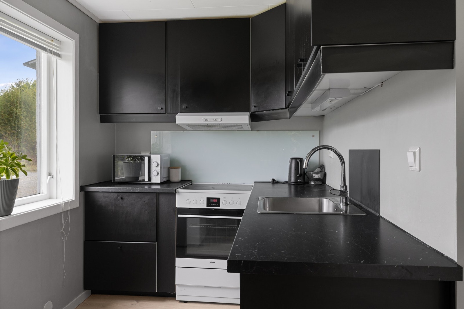 Kjøkkenet i utleiedelen er fra 2022, og har matte sorte fronter med håndtak. Laminat benkeplate. Splashboard bak komfyren. Galleribilde