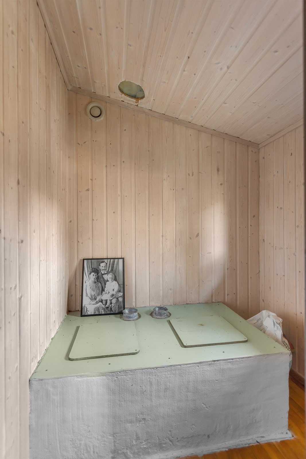 Toalettrom innredet med panel og toalett med kompostbeholder under gulvet. Galleribilde