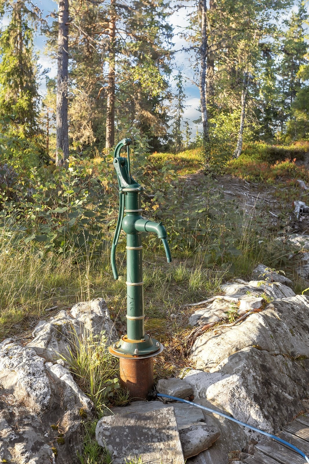 Vannpost med manuell håndpumpe tilknyttet privat borehull. Galleribilde