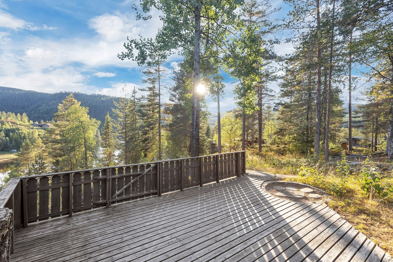 Fra verandaen er det åpen utsikt mot det skogkledde terrenget. Galleribilde