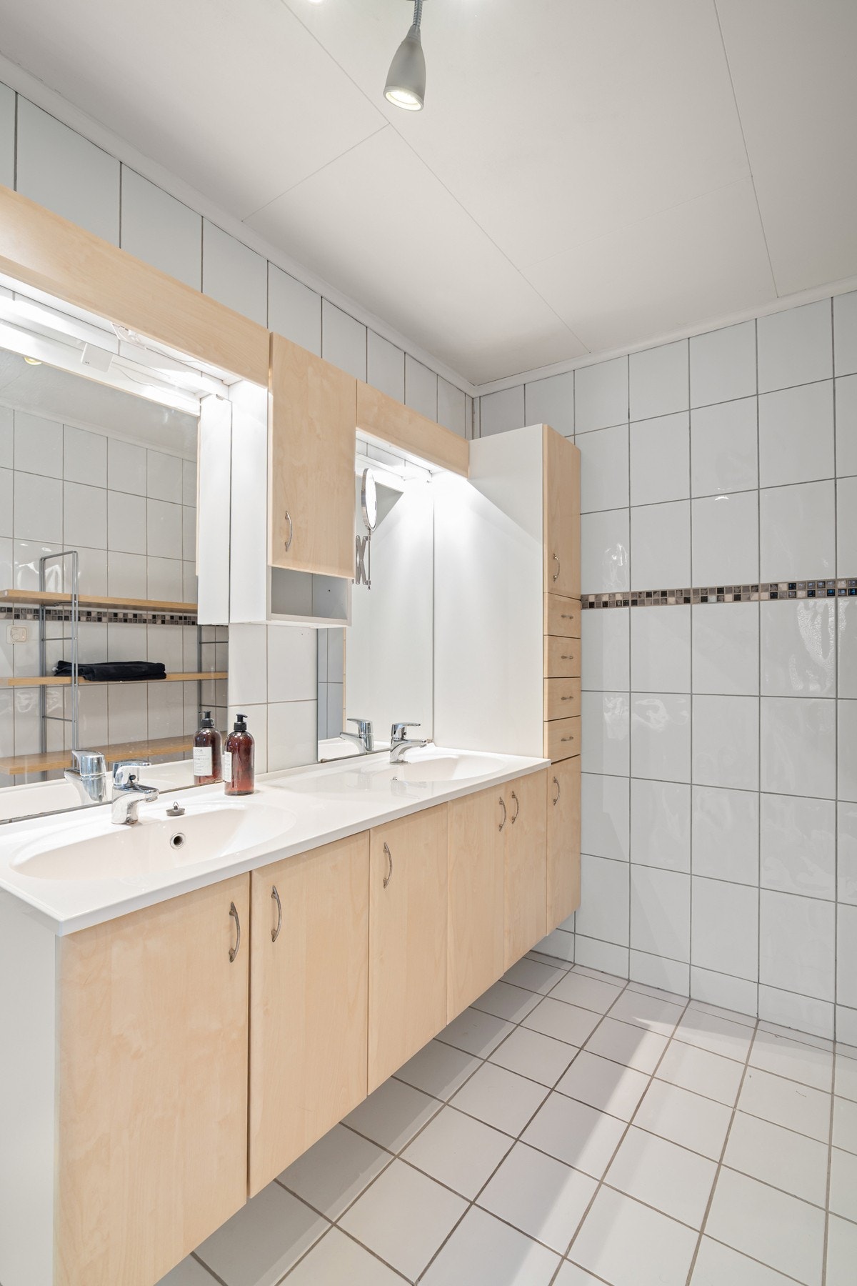 Badet ligger i 2. etasje og er av eldre dato, men er overflateoppgradert av eier. Rommet har flislagt gulv med varmekabler samt en kombinasjon av fliser og baderomsplater på veggene. Galleribilde