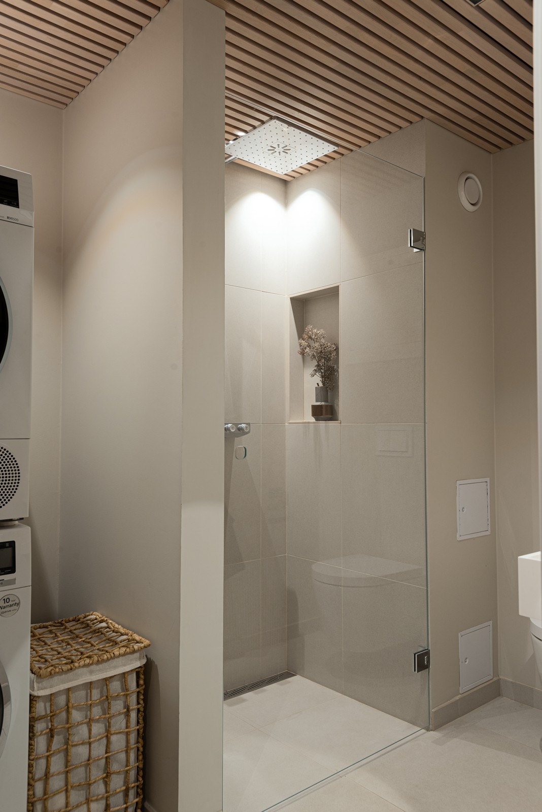 Badet har lyse store fliser, veggfestet wc, baderomsinnredning fra Corian, dusjhjørne og Tapwell kraner integrert Galleribilde