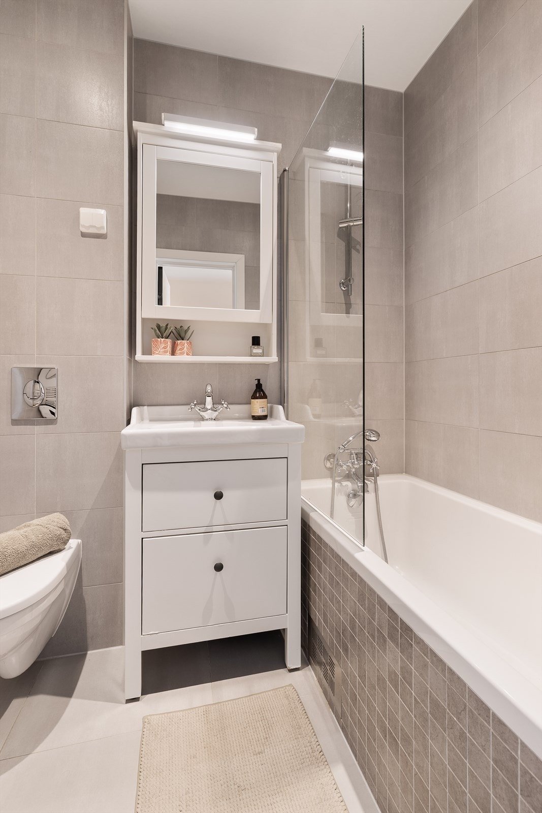 Badet er utstyrt med innebygget badekar, vegghengt toalett og gulvvarme. Galleribilde