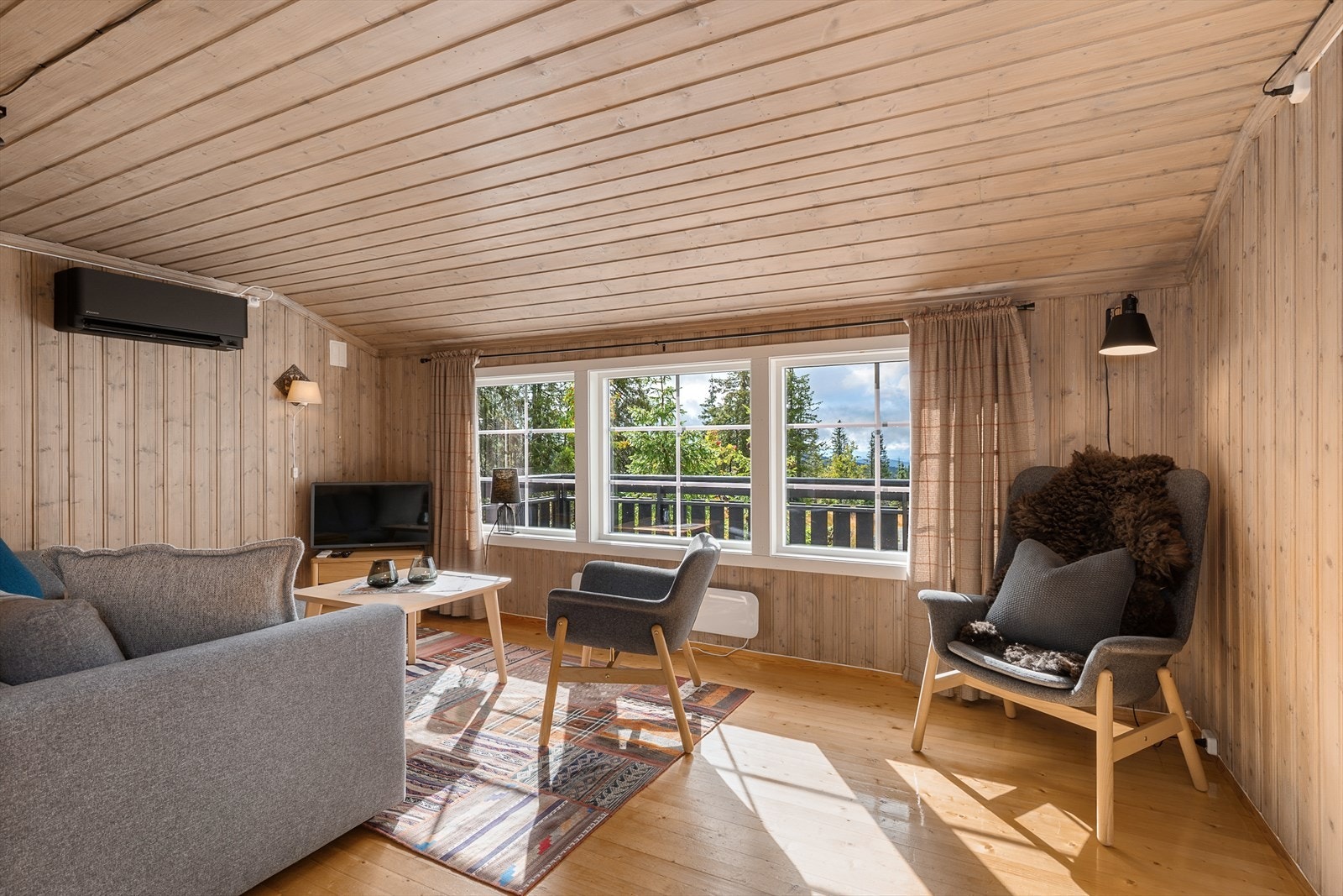 Stuen har store vindusflater som slipper inn rikelig med lys i rommet. Varmepumpe sørger for jevn oppvarming. Galleribilde