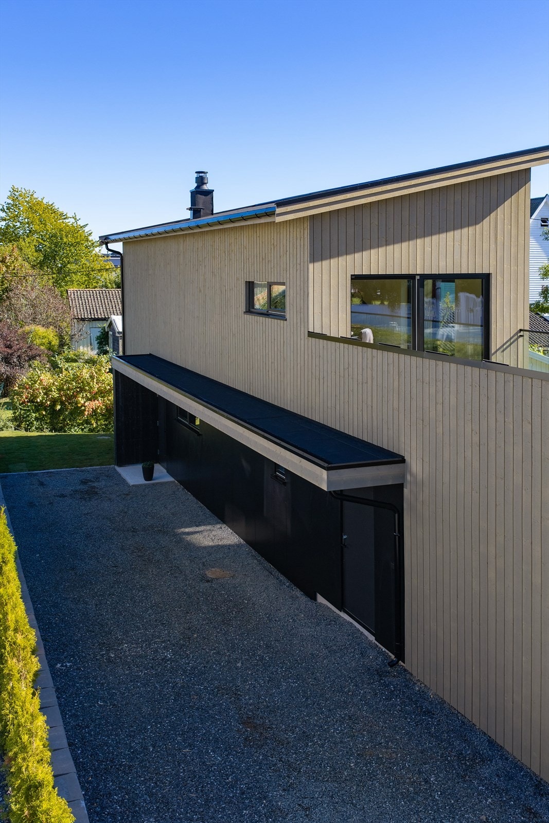 Fasaden har kledning beiset i Røykgrå fra Trebitt-serien til Jotun, kombinert med fasadeplater og sorte detaljer. Galleribilde