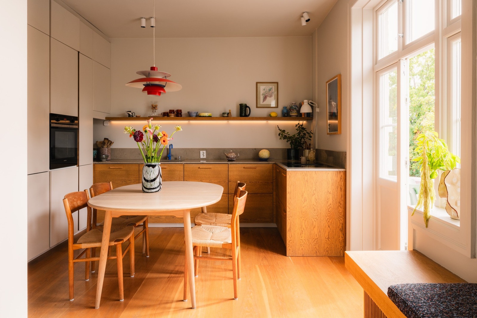 Smakfullt innredet kjøkken med høyskap plassert på den ene siden. Galleribilde