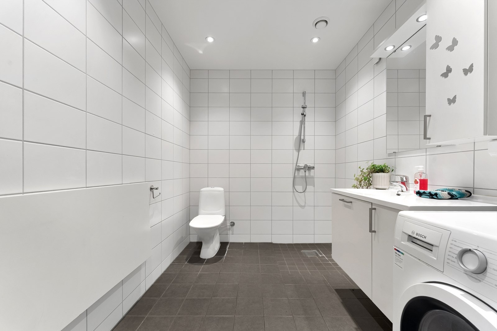 Flott, flislagt bad fra 2015 med gulvvarme og downlights i himling. Det er opplegg for vaskemaskin. Galleribilde