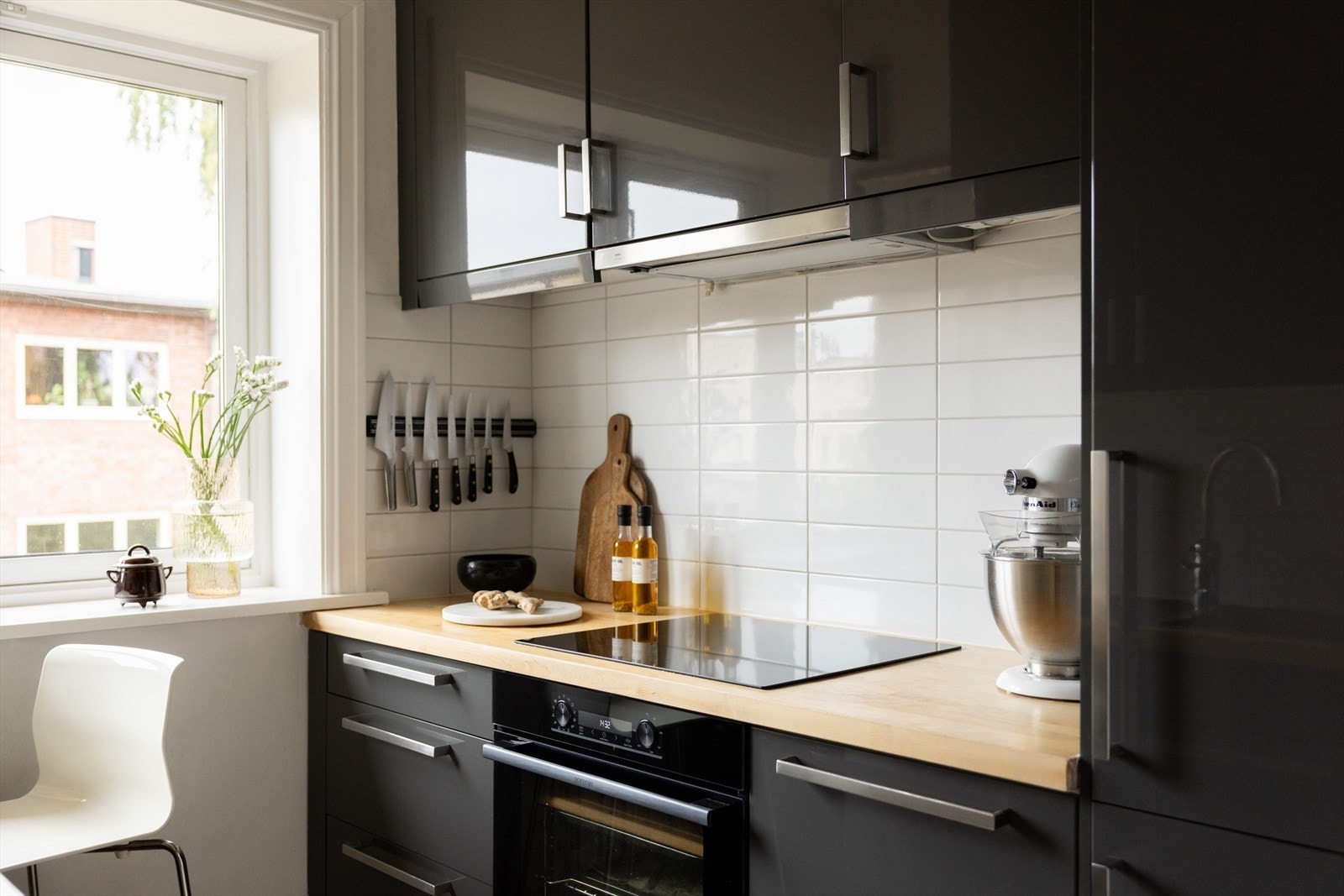 Mellom benk og overskap er det lyse fliser som gir et enkelt og tidløst uttrykk. Galleribilde