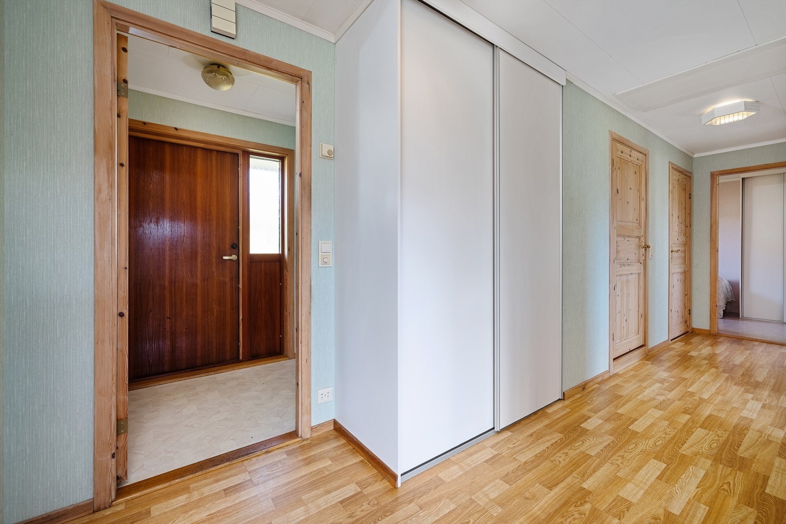 Romslig hall med garderobeløsning og adkomst til boligens øvrige rom. Galleribilde