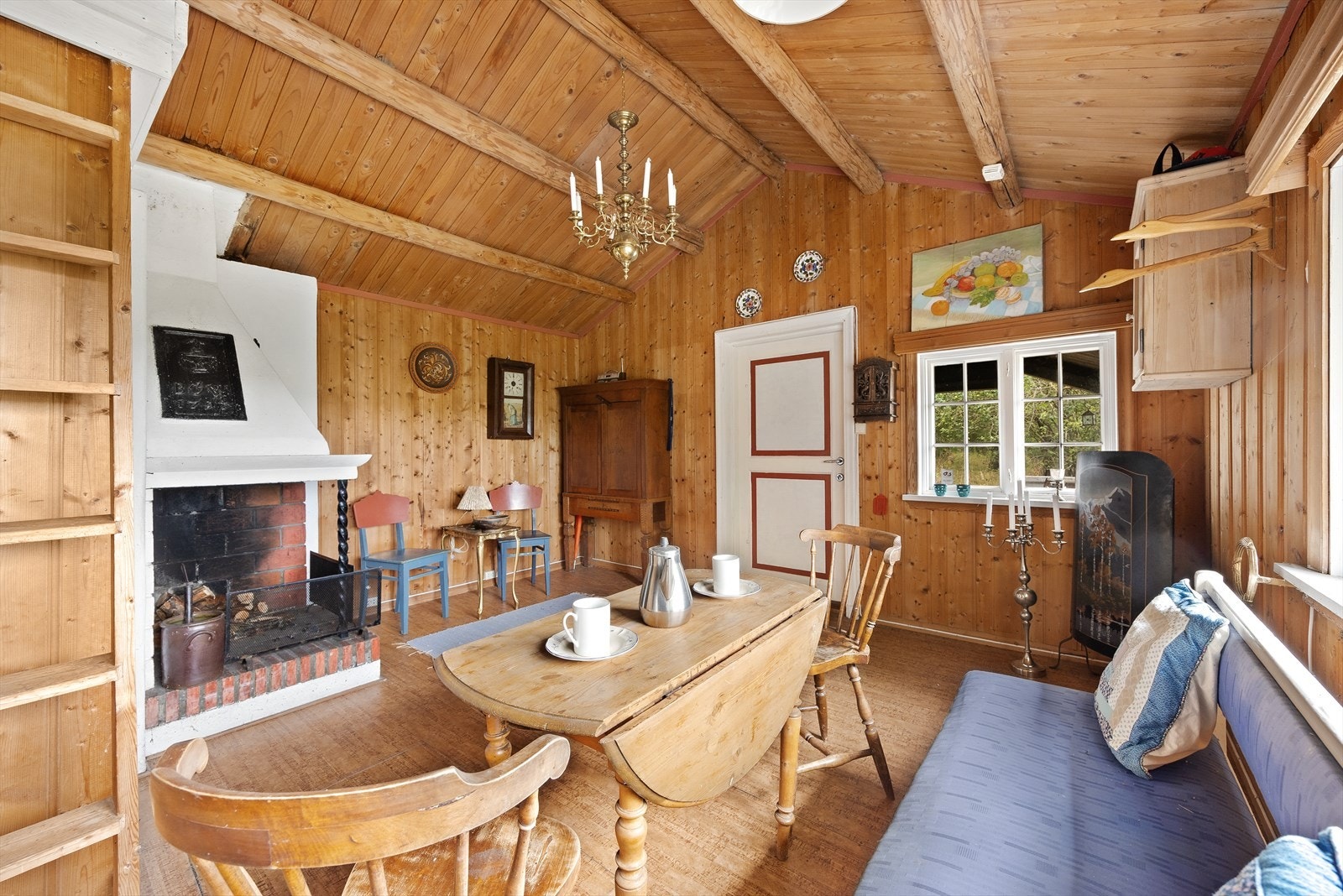 Det er fin plass til sofagruppe, godstoler og spisebord, og en oppmurt, åpen peis kan gi lun hygge og ekstra varme på kjøligere kvelder. Det er usikkert om peisen er i funksjon. Galleribilde
