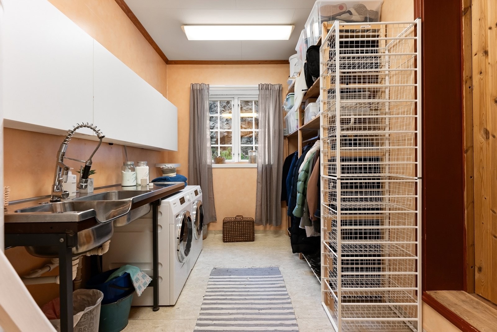 Praktisk og romslig vaskerom med god plass til både klesvask, oppbevaring og organisering. Galleribilde