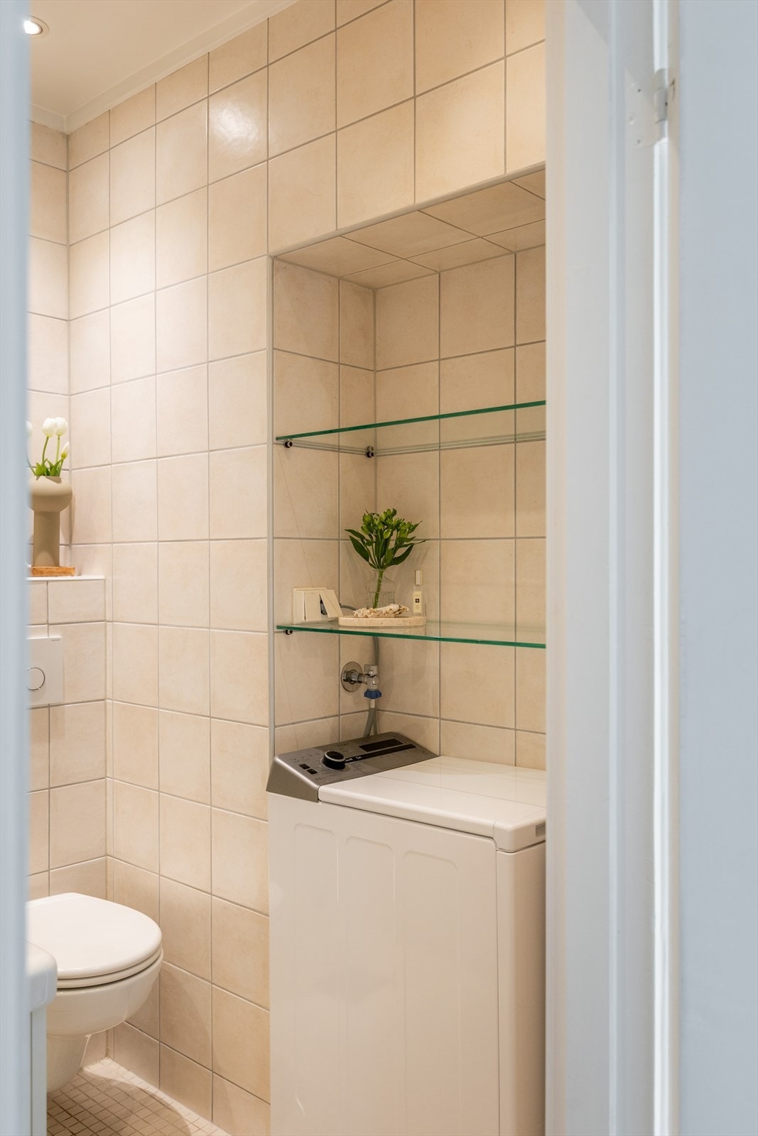 Badet er utstyrt med innredning med nedfelt servant, speilskap, veggmontert toalett og dusjhjørne med regnfallsdusj bak foldedører i glass. Galleribilde