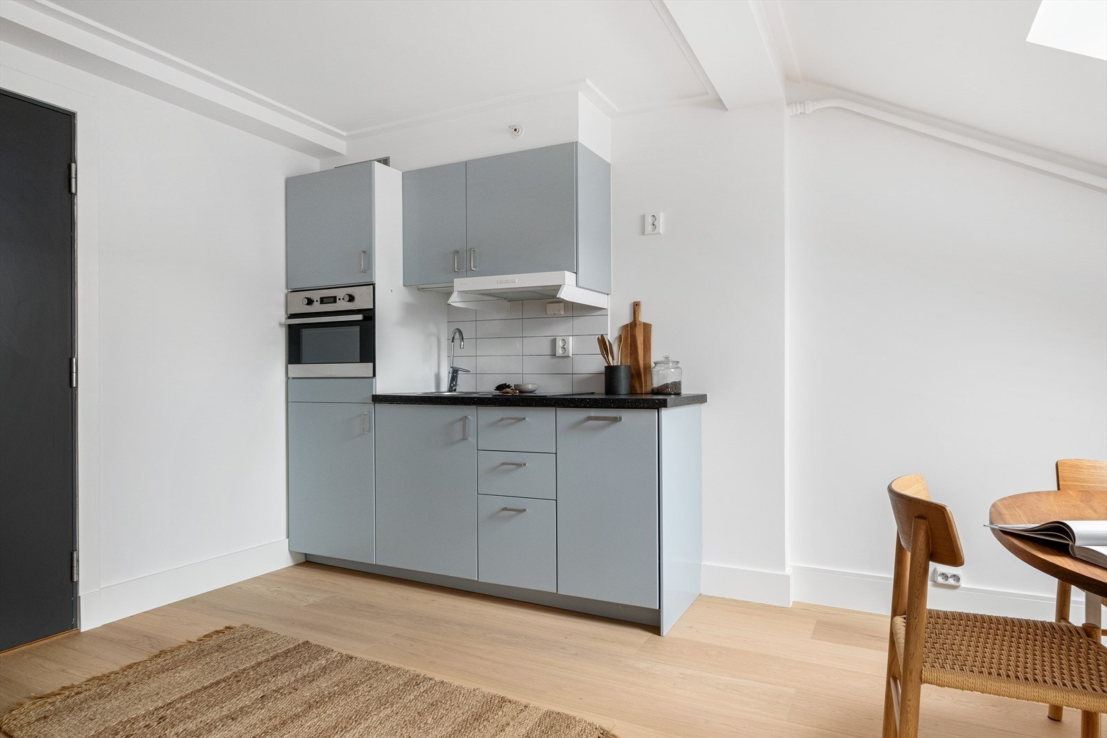 Kjøkkeninnredningen er av tidsriktig, glatt utførelse fra IKEA med fliser over benk, laminat benkeplate med nedfelt stålkum og keramisk platetopp. Galleribilde