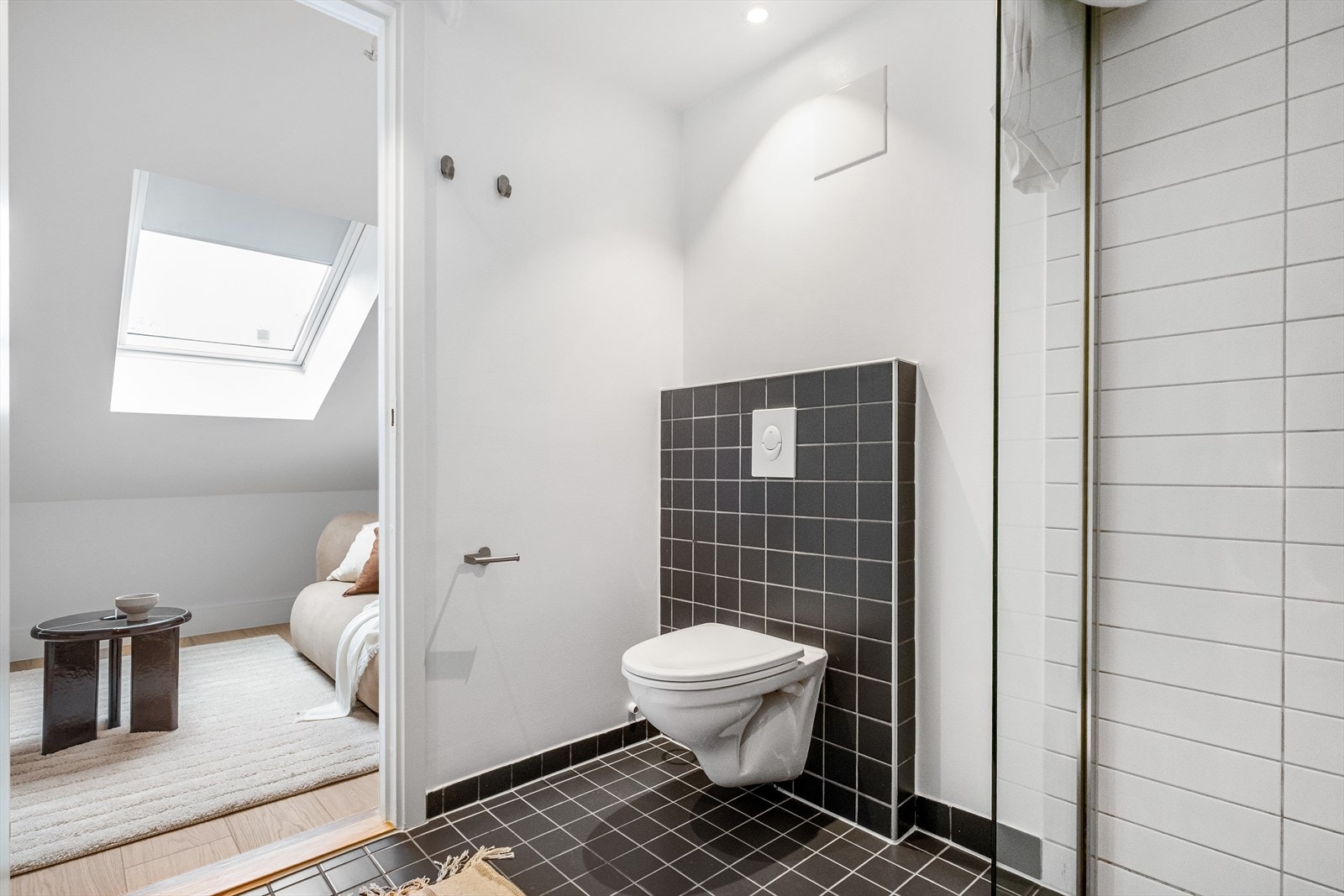 Badet er utstyrt med dusjvegger/dusjhjørne, servant og vegghengt klosett med innebygd sisterne. Galleribilde