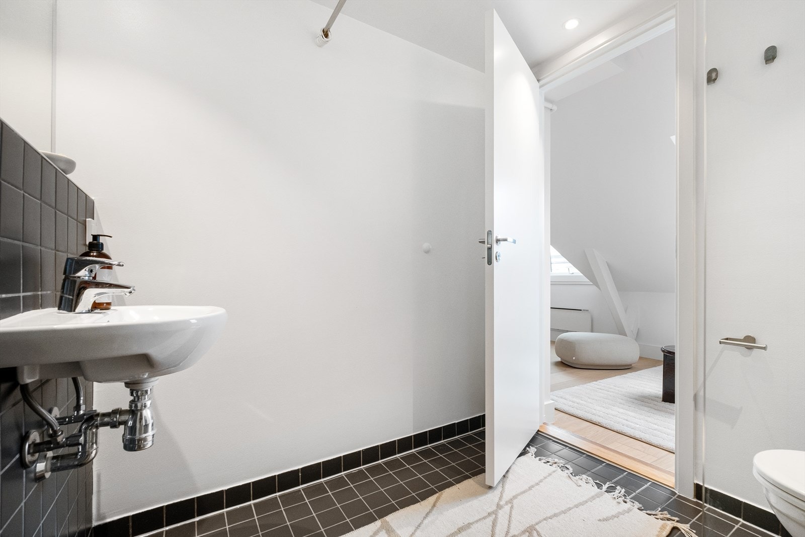 Veggene på badet har flislagte og malte overflater, og gulvet er flislagt med varmekabler. Galleribilde