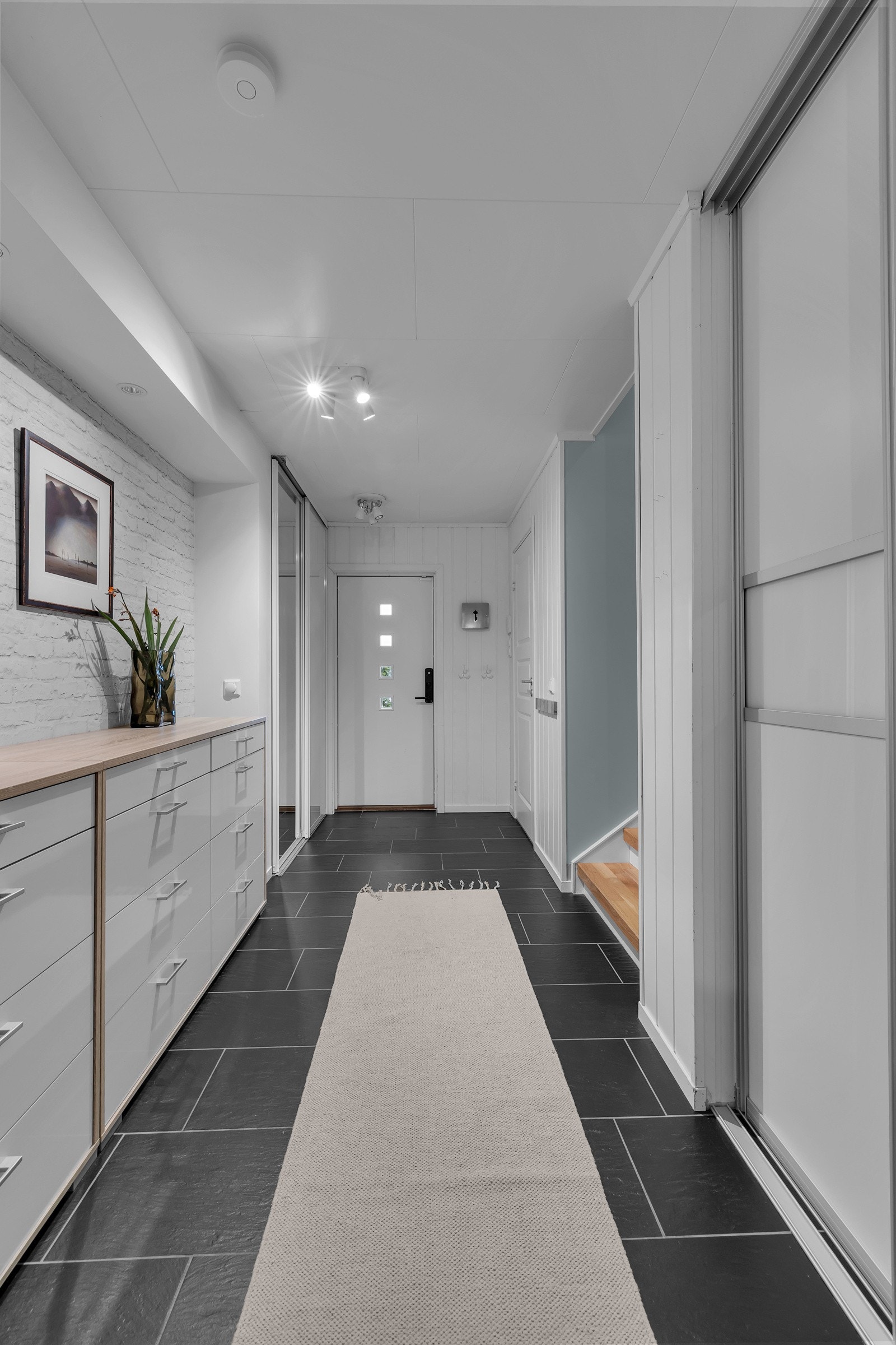 Velkommen inn! Det første som møter deg er dette romslige inngangspartiet hvor det er skyvedørsgarderobe og stor walk-in garderobe Galleribilde