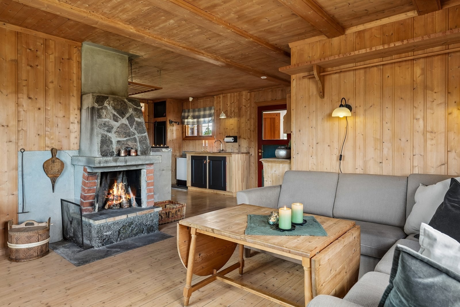 En åpen peis, delvis forblendet med naturstein gir god varme og en hyggelig stemnings til rommet på friske høstkvelder. Galleribilde