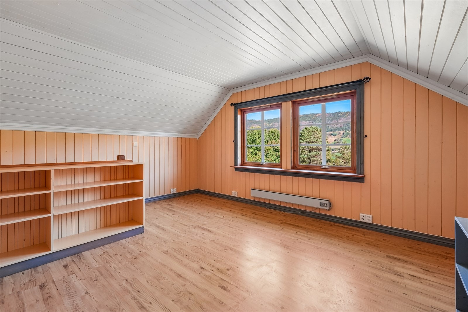 Her er det en åpen, romslig stue med flott utsikt utover området. Som i etasjens øvrige rom, er det her sjarmerende skråtak i deler av rommet. Galleribilde