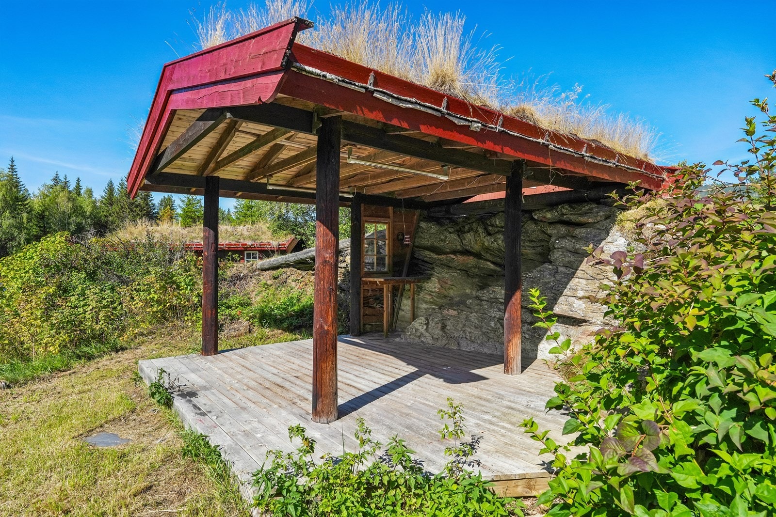 Som en hyggelig del av uteområdet er det laget en gapahuk med torv på taket. Her er det en romslig platting av terrassebord og god plass til sittegruppe, slik at familie og venner kan nyte gode dager og lune kvelder. Galleribilde