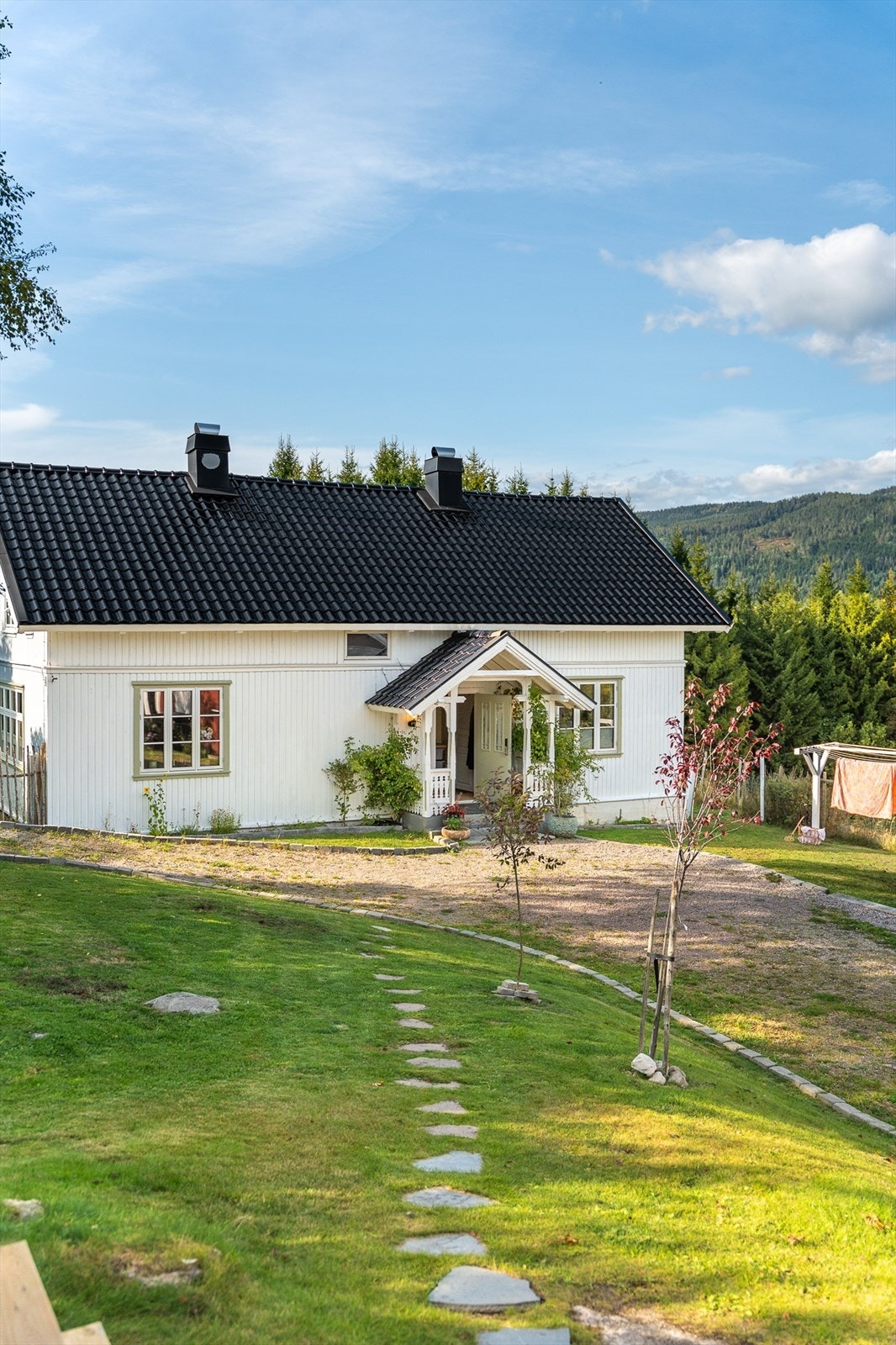 Dette gårdstunet er pent og koselig opparbeidet med diverse vekster, steinsatte gangveger, dam og hageområde! Galleribilde