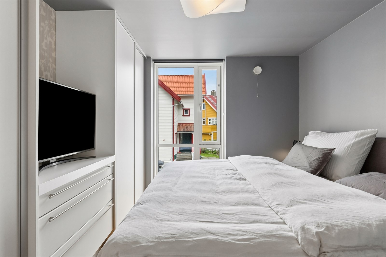 Rommet er innredet med romslige garderobeskap med slette skyvedører. Galleribilde