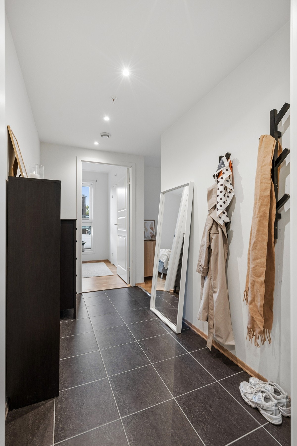 Entré med mørke fliser på gulvet og behagelig gulvvarme. Galleribilde
