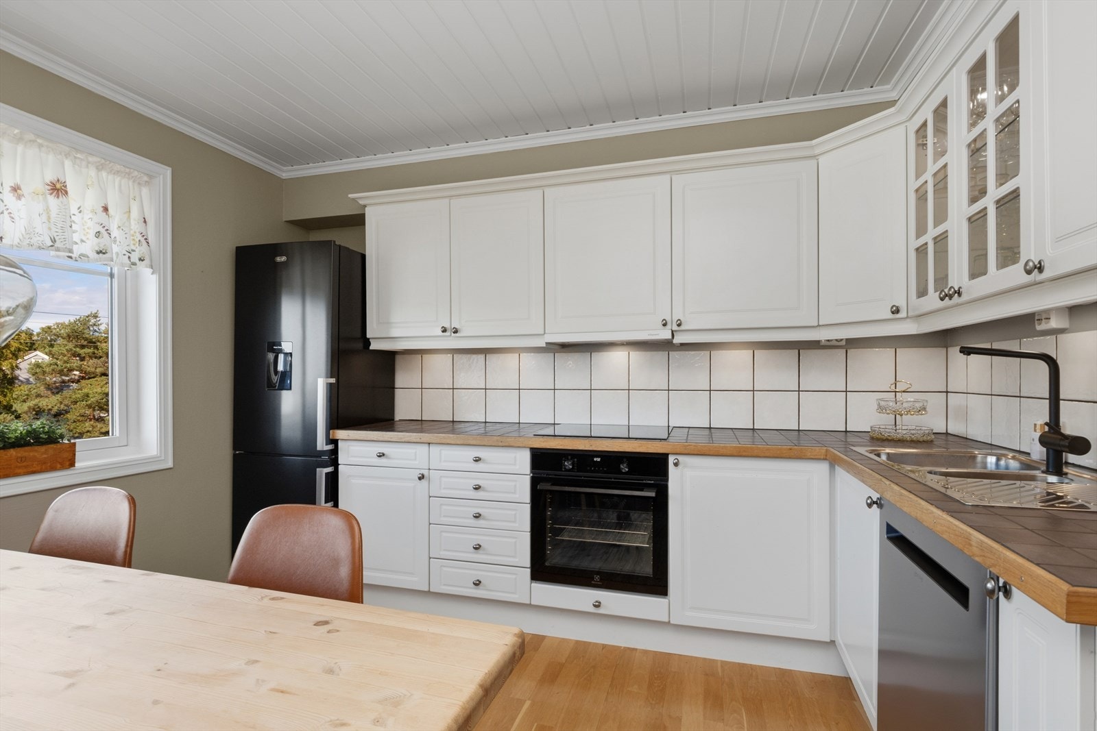 Kjøkkenet fremstår med et tiltalende uttrykk og har en luftig atmosfære med godt lysinnslipp fra vinduene. Planløsningen gir fine arbeidsflater og gode oppbevaringsmuligheter, samtidig som rommets design gir fleksibilitet for ulike møbleringsløsninger. Galleribilde