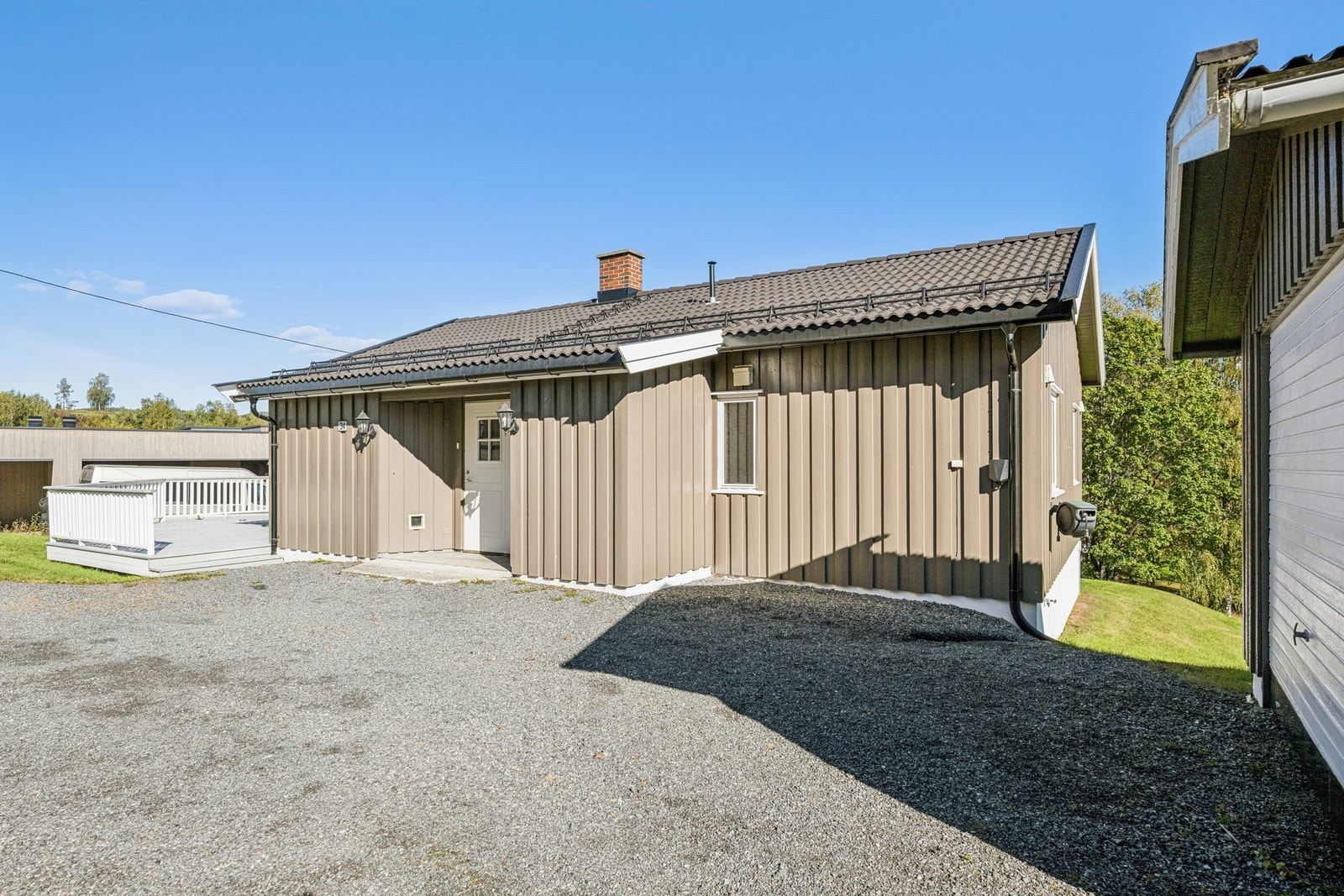Eiendommen har gruslagt gårdsplass med gode parkeringsmuligheter, elbillader monter på husvegg og egen garasje. Galleribilde