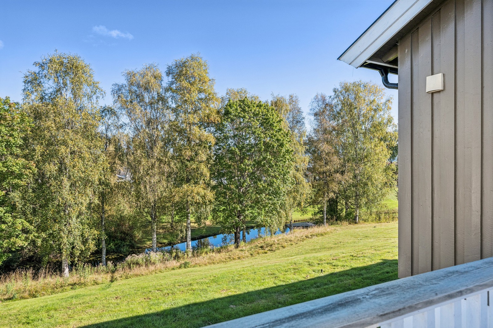 Fra terrassen ser du utover deler av hagen, samt elven. Galleribilde