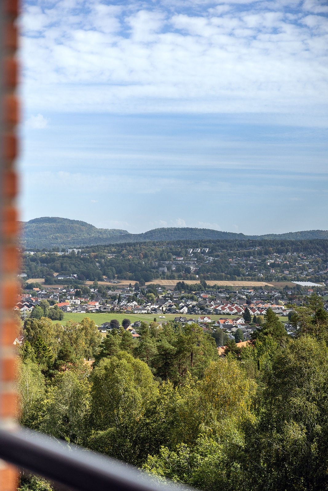 Utsikten strekker seg utover bebyggelsen og mot de omkringliggende skogsområdene. Galleribilde