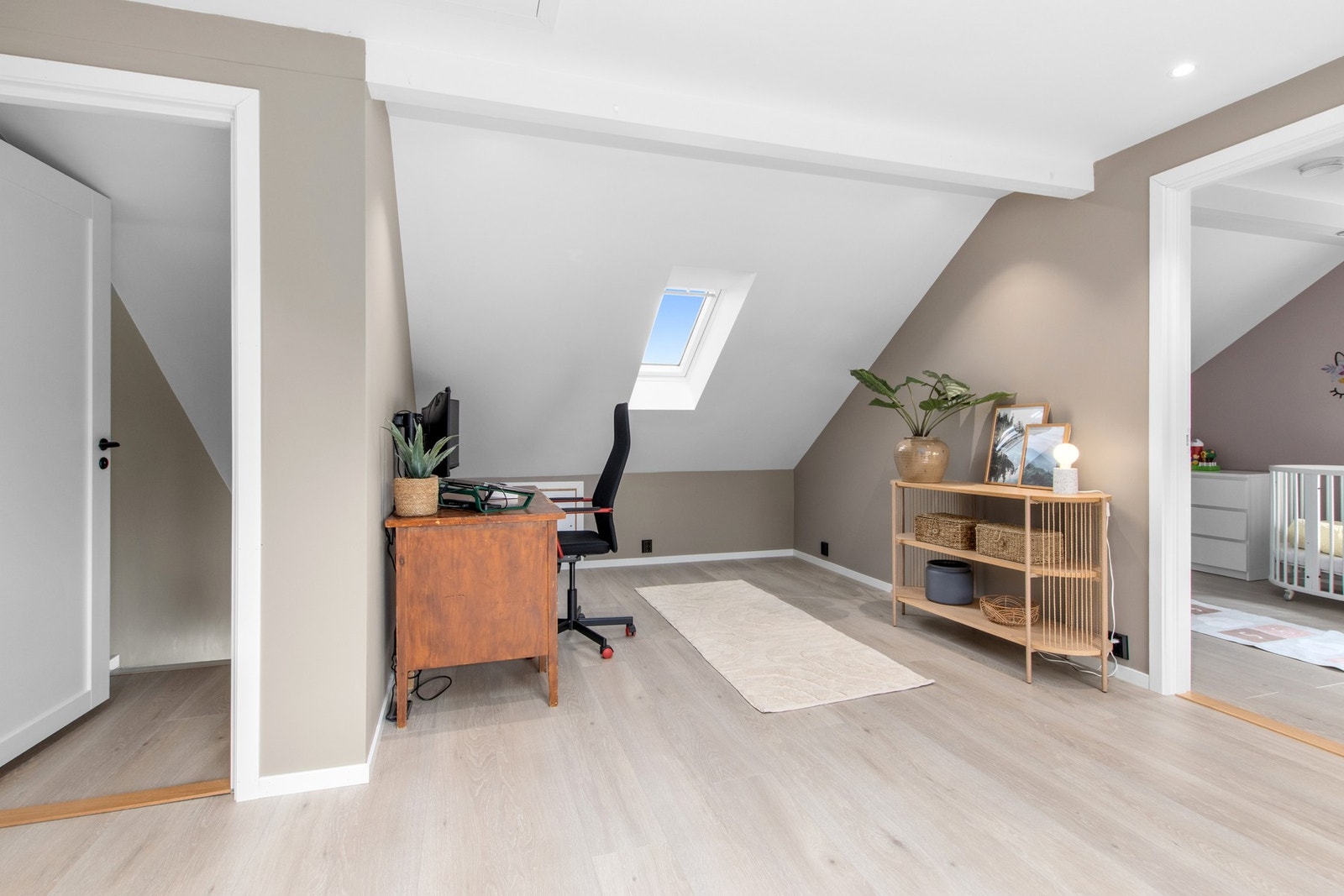 Loftstuen fungerer som et fleksibelt oppholdsrom med plass til både hjemmekontor, TV-stue eller lekesone. Galleribilde