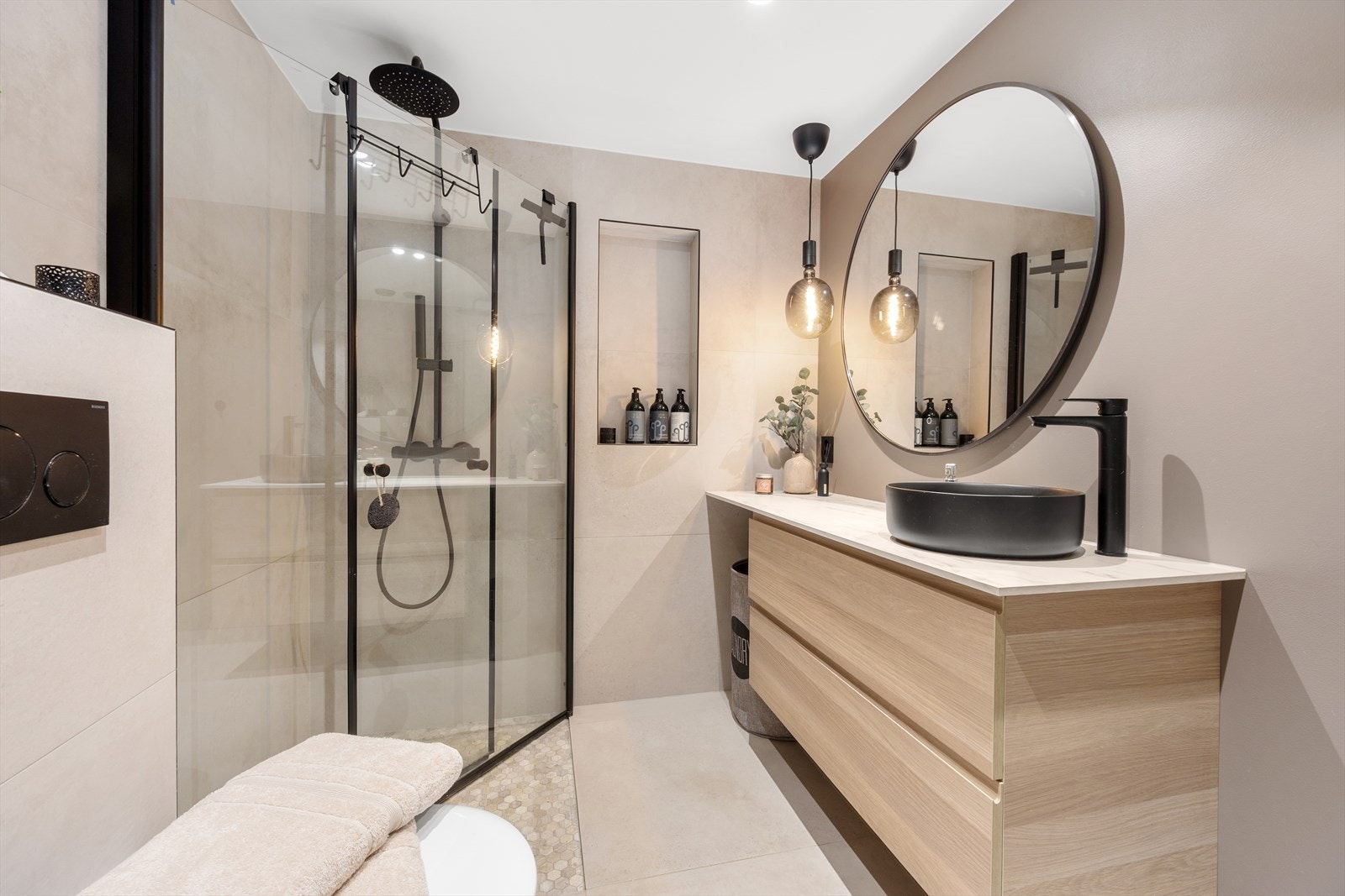 Badet har stor servantseksjon med skuffer, speil med belysning og fordelerskap for rør-i-rør. Galleribilde