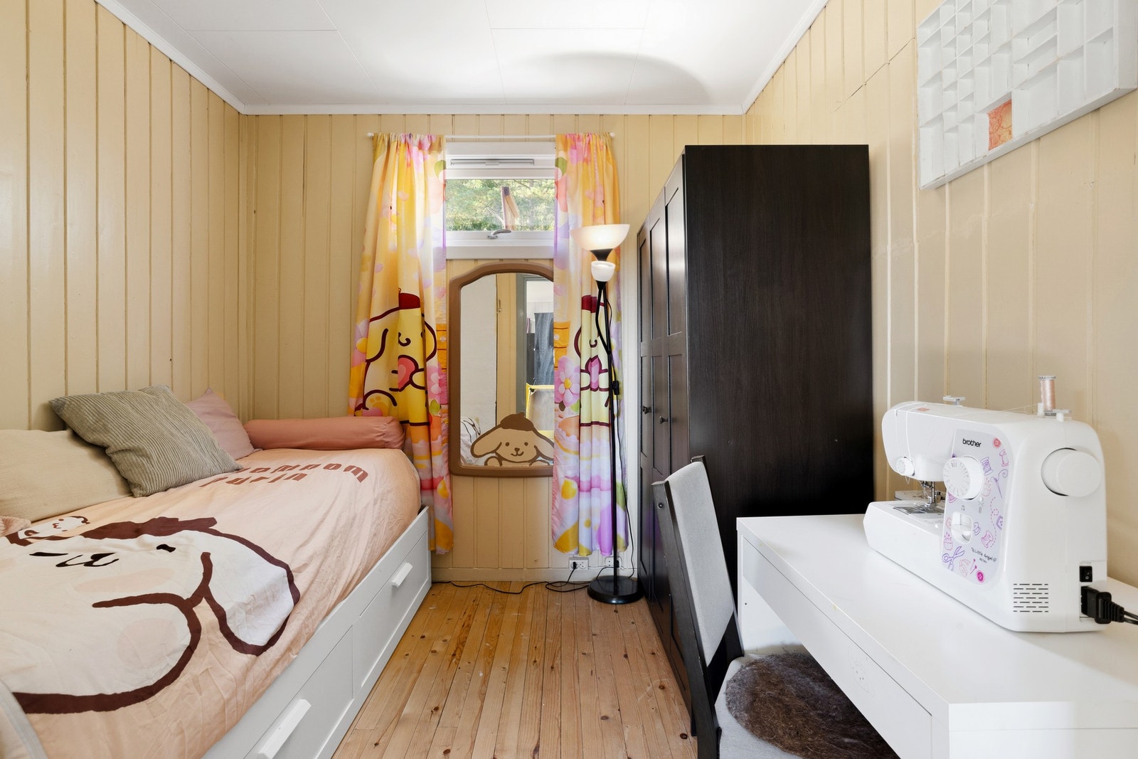 Soverom med tregulv, malt panel på vegger og takplater i himling Galleribilde