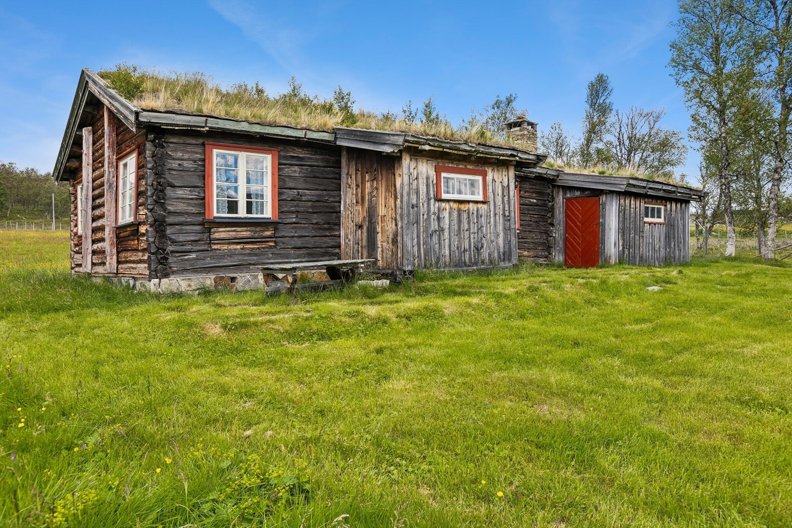 Hytta ved sætra er en tradisjonell tømmerhytte med torv på taket. Galleribilde
