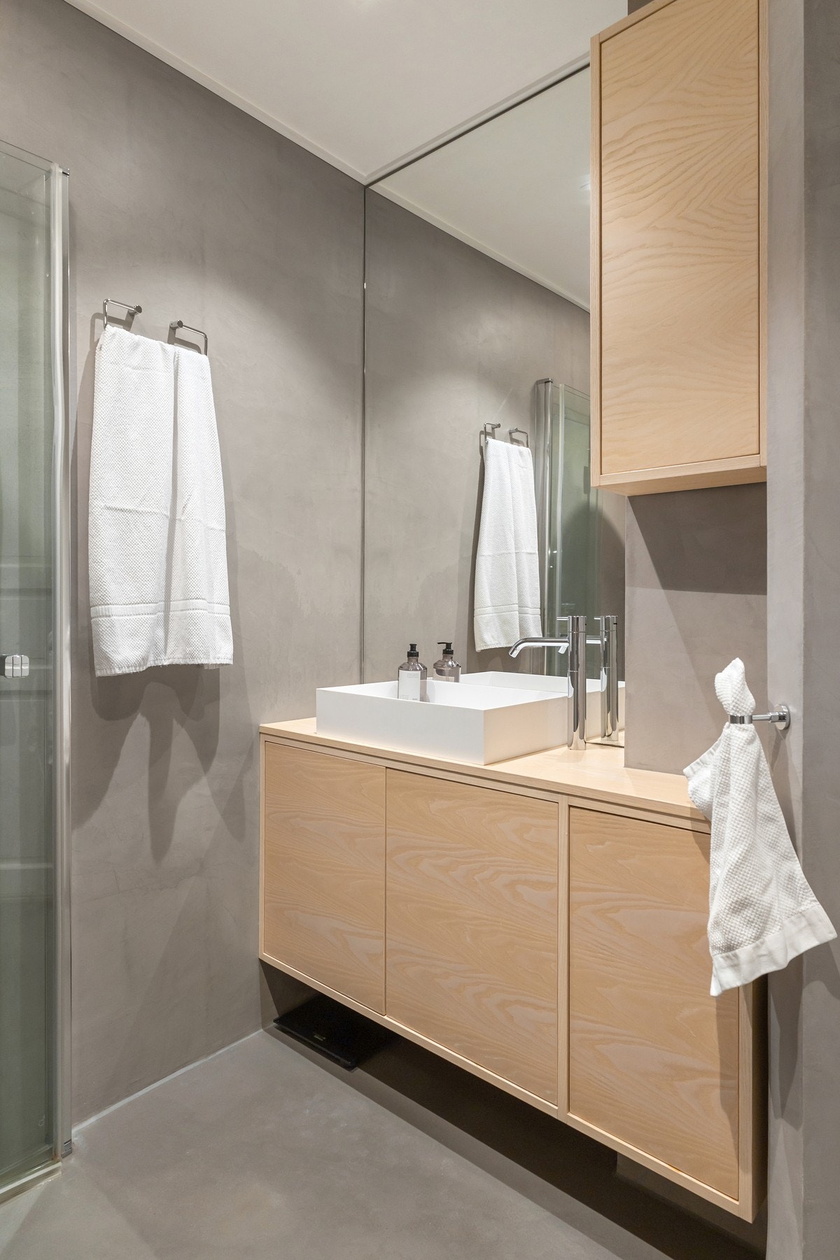 Praktisk bad i hovedetasjen med moderne uttrykk og microsement på overflatene. Galleribilde