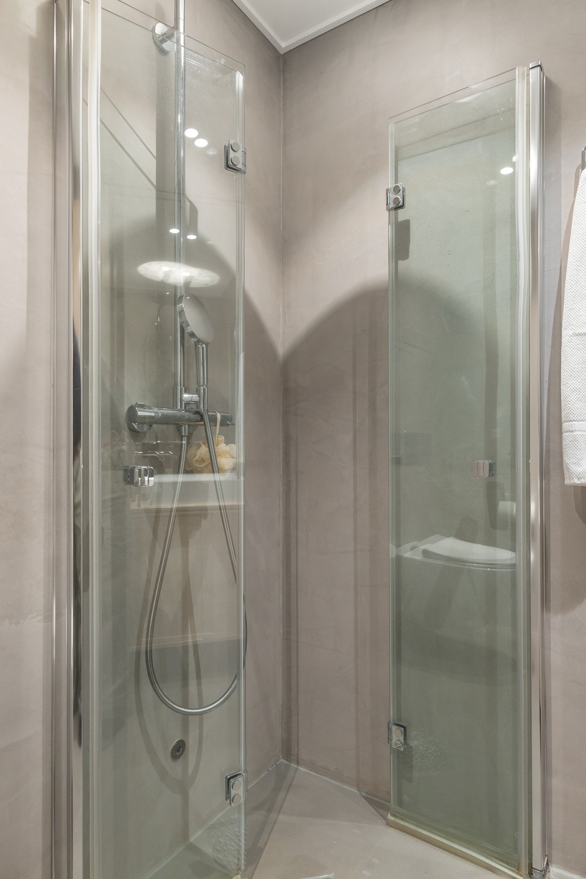Badet er innredet med dusjhjørne, vegghengt servantinnredning og vegghengt toalett. Galleribilde