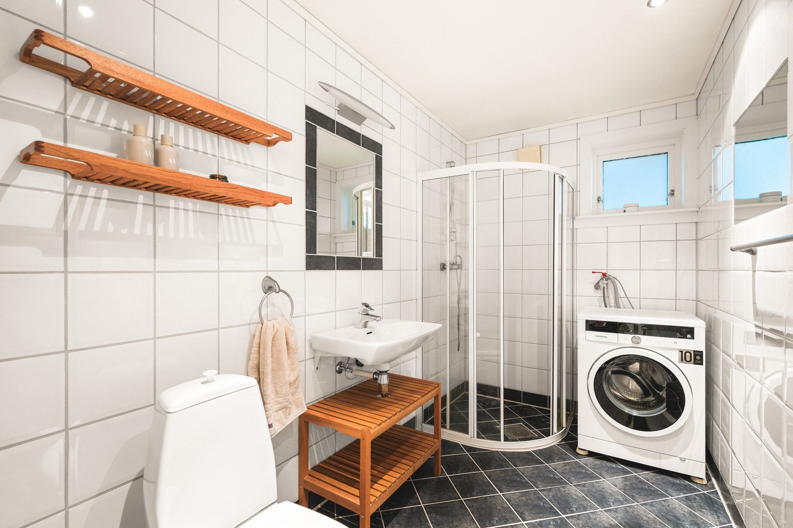 Badet i underetasjen har en funksjonell innredning med toalett, helstøpt servant og dusjdører i klart glass. Galleribilde