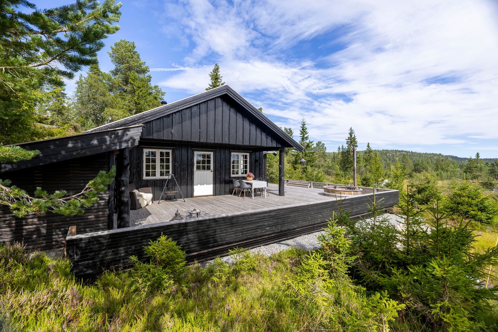 Hytta ligger fint tilpasset terrenget, omgitt av natur og med romslige utearealer. Galleribilde