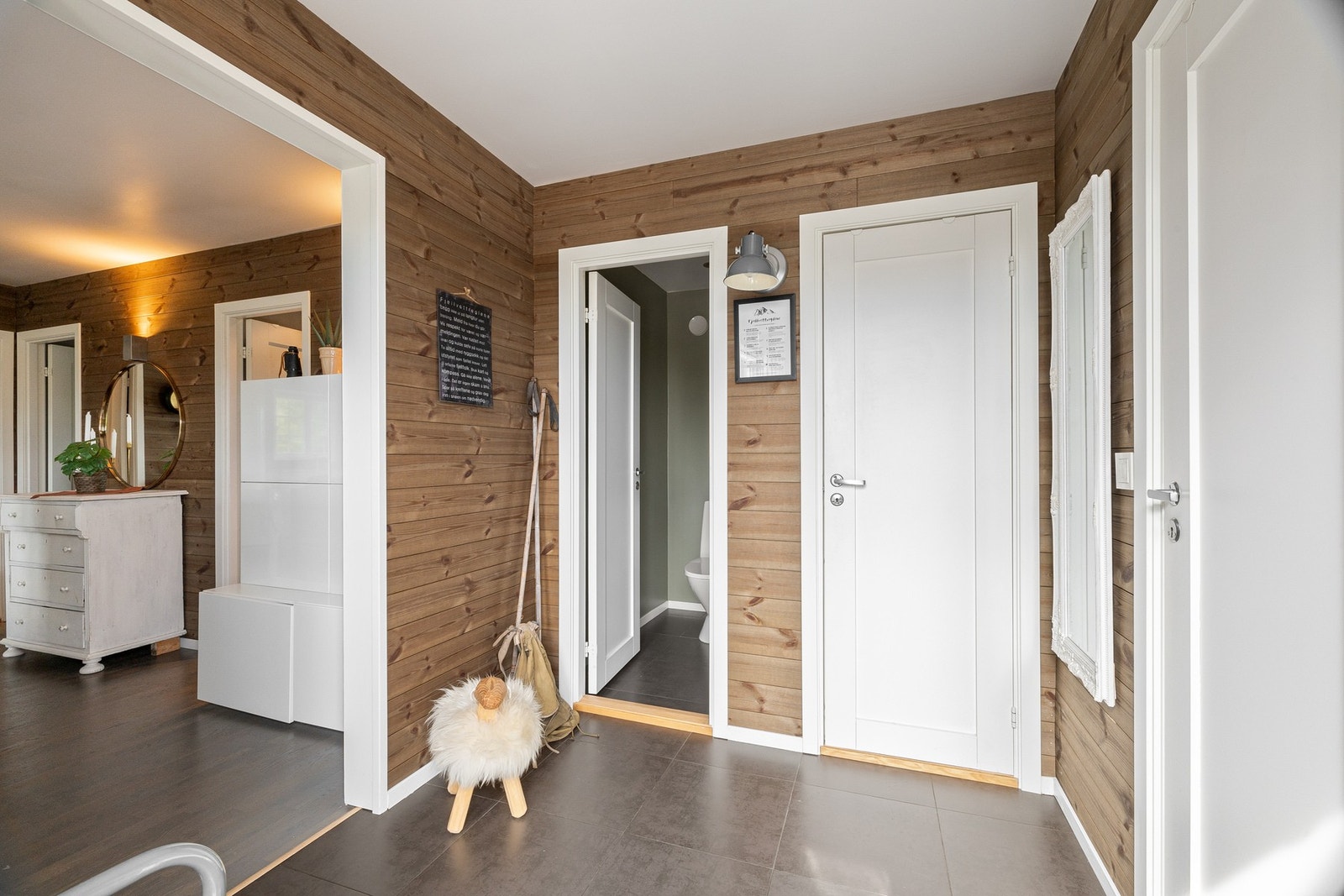 Entréen har flislagt gulv, trepanel på veggene og malt himling, og gir adkomst videre til hyttas øvrige rom. Galleribilde