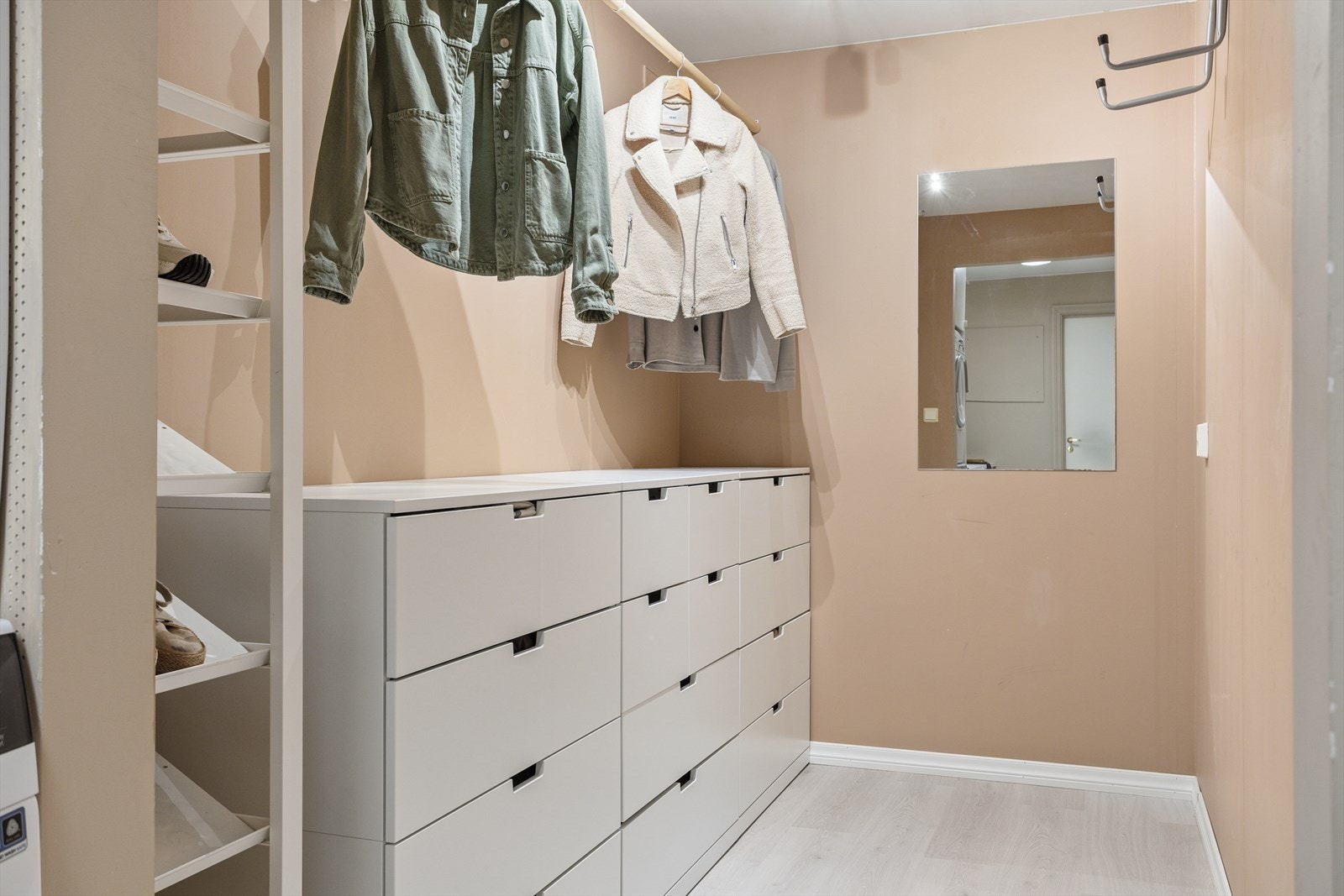 Romslig walk-in-garderobe med praktiske oppbevaringsløsninger. Galleribilde