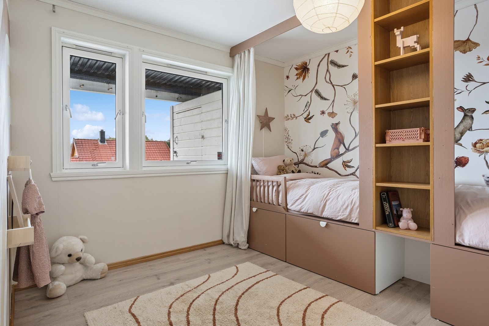 Koselig barnerom med store vindusflater som slipper inn rikelig med dagslys. Galleribilde