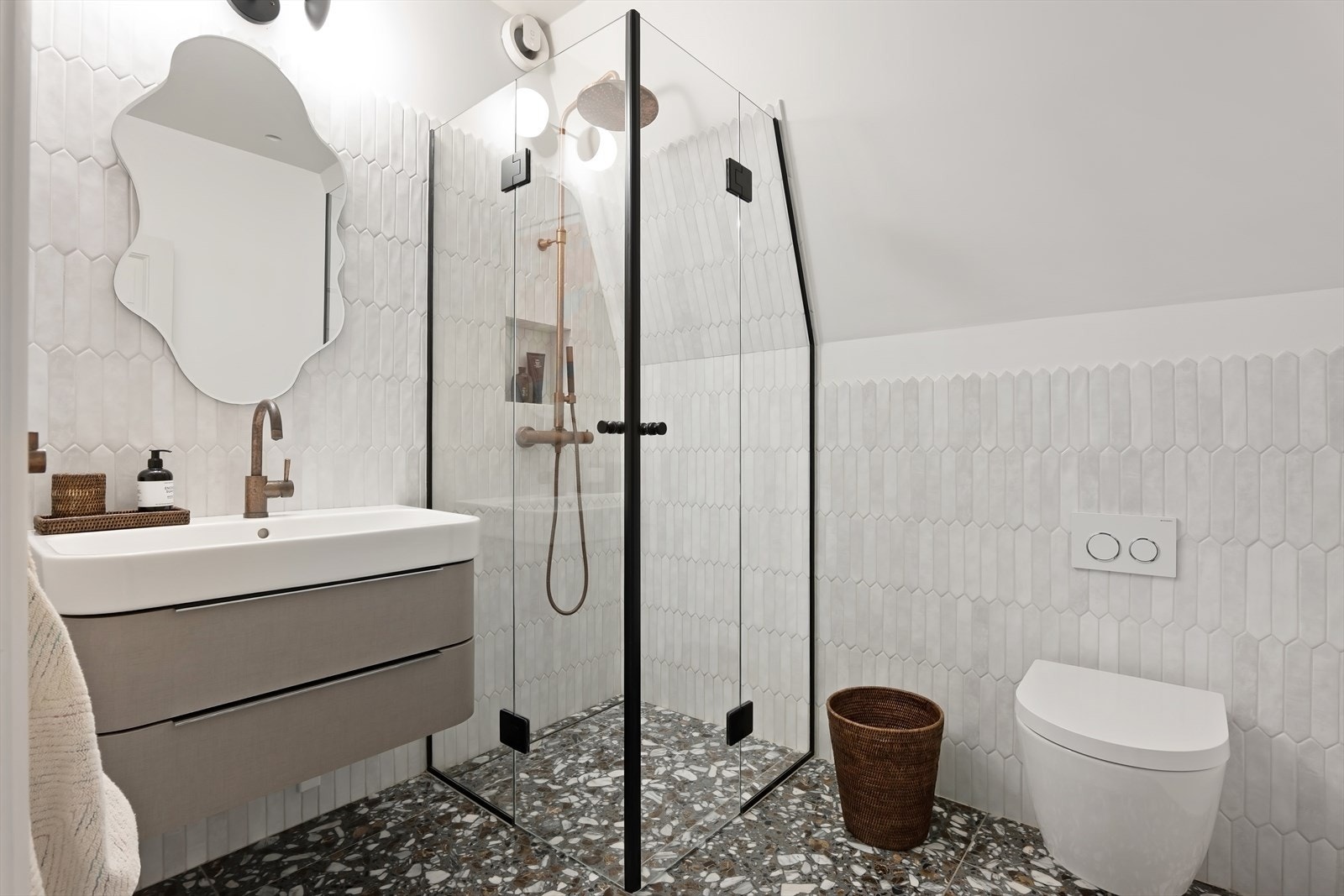 Lekkert baderom 3 med servantskap, dusj og toalett. Smakfulle Terrazzo-fliser på gulv. Axor armaturer. Galleribilde
