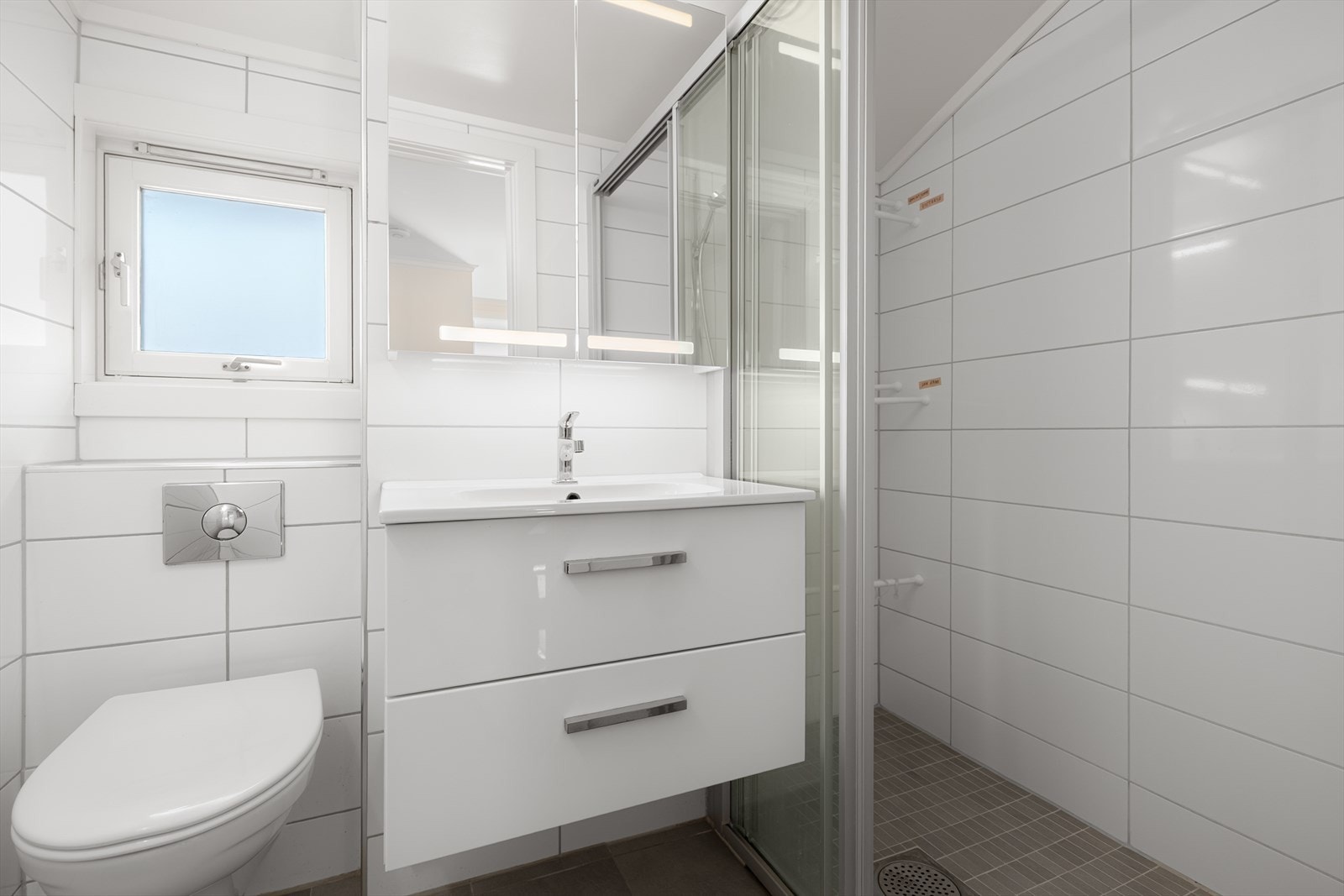 Badet er innredet med klosett, speilskap og servant med innredning. Galleribilde