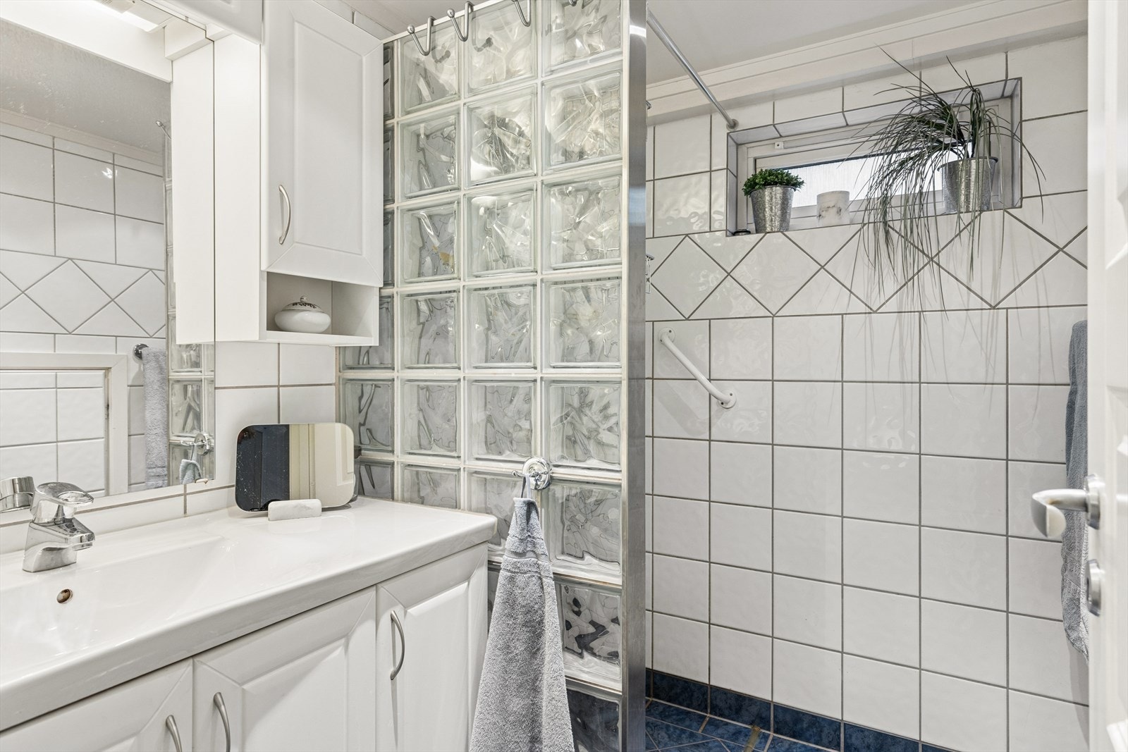 Badet er flislagt og utstyrt med varmekabler i gulv og dusjnisje i glassbyggerstein. Galleribilde