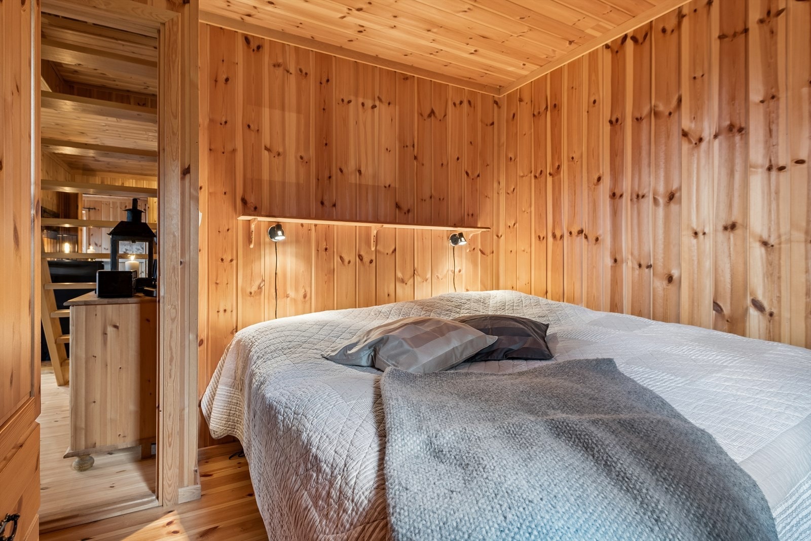 Soverom i første etasje innredet med dobbeltseng og panelte vegger. Galleribilde
