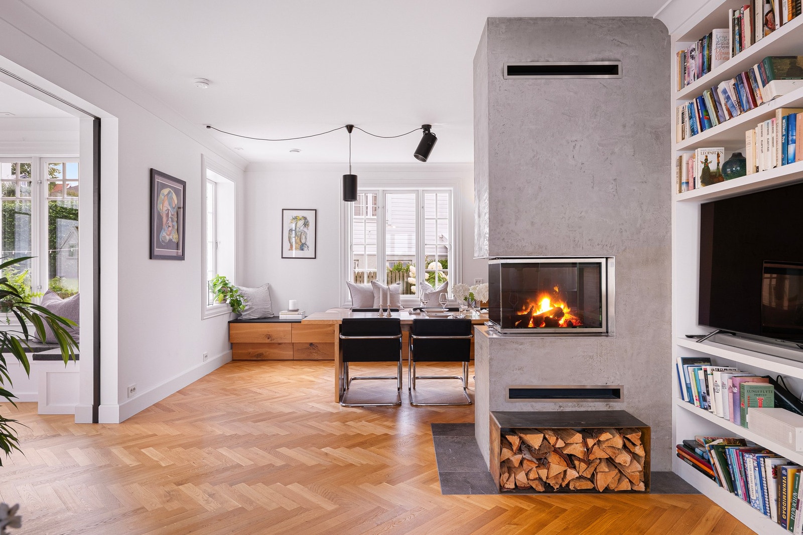 Mellom stue- og spisestuesonen er det en stilfull, oppmurt peis med moderne innsats, og ved stuesonen er det plassbygde bokhyller. Galleribilde